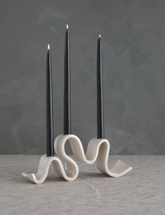 three black candles are sitting next to each other in front of two smaller ones with one candle sticking out