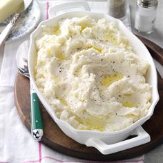 a white bowl filled with mashed potatoes on top of a wooden table