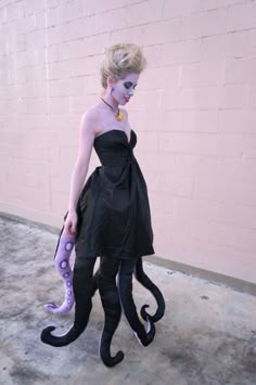 a woman dressed in black and purple with an octopus costume