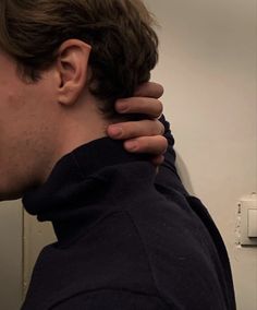 a man with his hand on the back of his neck