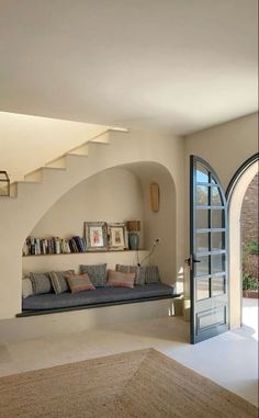 a living room filled with furniture and a spiral staircase leading up to the second floor