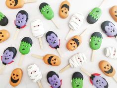 there are many halloween treats on the table with faces painted on them, including marshmallows and candies