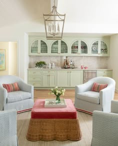 a living room filled with furniture and a chandelier hanging over the top of it