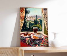 a painting is hanging on the wall above a table with a vase and plate of food