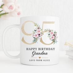 a white coffee mug with pink flowers and the words happy birthday grandma printed on it