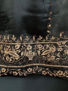 Item Details.  A striking dress length of black silk satin from Europe in the early 20th century. Embroidered in the Oriental style in beautiful gold work. There are also some little mirrors, possibly added later. Would be fantastic for a variety of projects, fashion and apparel or home decor. Measurements. 94 x 31 inches (240 x 79 cm) Condition In overall good condition for a textile of this antiquity, a few tiny holes but there's plenty of very usable fabric.  Further Notes. We have lots more original and quality vintage items in our shop, https://www.etsy.com/uk/shop/TheTextileTreasury Where possible, we use recycled packaging when shipping items. Black And Gold Embroidery, Formal Intricate Embroidered Silk Fabric, Silk Fabric With Gold Embroidery For Festivals, Gold Silk Embroidered Fabric For Formal Occasions, Traditional Embroidered Fabric For Evening, Traditional Intricate Embroidered Fabric For Evening, Elegant Ceremonial Silk Embroidered Fabric, Traditional Evening Resham Embroidered Fabric, Black Raw Silk Embroidered Fabric For Wedding