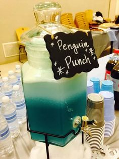 there is a blue and green liquid in a jar with a sign that says penguin punch