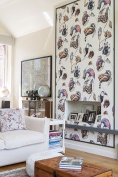 a living room filled with furniture next to a wall covered in pictures and bookshelves