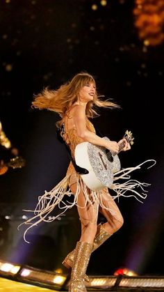 a woman with a guitar is performing on stage