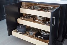 an open cabinet with pots and pans in it