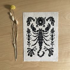 a piece of paper sitting on top of a wooden table next to dried flowers and scissors