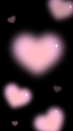 some pink hearts on a black background