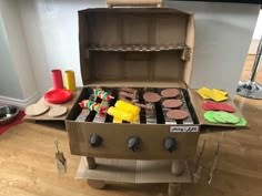 an open box filled with food on top of a hard wood floor next to a stove