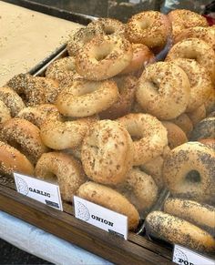 many different types of bagels on display in a case