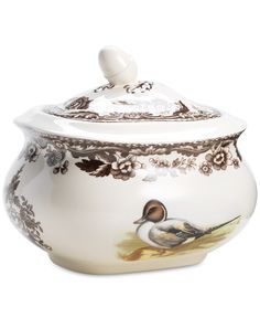 a ceramic pot with a bird painted on the front and bottom, sitting next to a white background