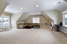 an empty living room with two windows and a couch in the middle of the room