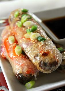 some food is on a white plate with sauce and green onions around it in a bowl