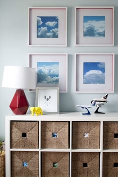 a white dresser topped with baskets and pictures