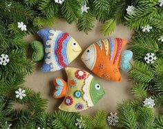 two colorful fish ornaments sitting on top of a christmas tree