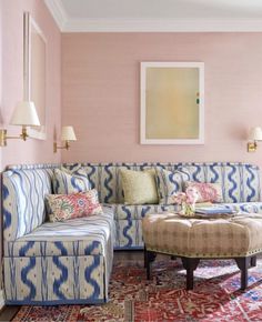 an image of a living room with pink walls and blue couches in the corner