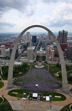 an aerial view of a large crowd gathered in front of the gateway arch