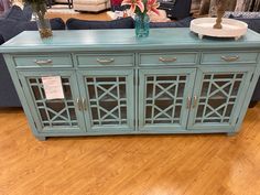 a blue sideboard sitting on top of a hard wood floor