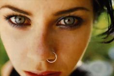 a woman with piercings on her nose looking at the camera