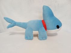 a blue stuffed dog with a red collar on it's neck and eyes closed