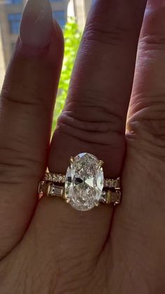 a close up of a person's hand with a diamond ring on their finger