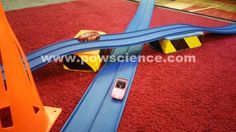 a toy train set laying on top of a red carpeted floor next to an orange traffic cone