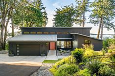 a modern house surrounded by trees and plants