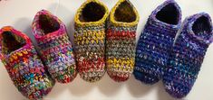 four crocheted slippers are lined up on a table