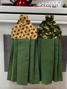 two kitchen towels hanging on the oven rack with sunflowers and green polka dots