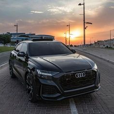 an audi car parked on the side of the road at sunset or dawn with its lights on