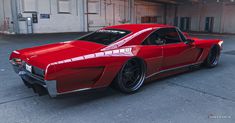 a red sports car parked in an empty parking garage with no one around the vehicle