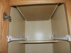 the inside of a closet with two shelves and one door open to reveal an empty shelf