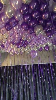 purple and white balloons hanging from the ceiling