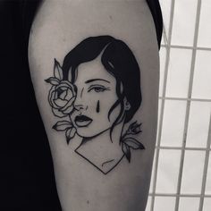 a black and white photo of a woman with flowers on her arm