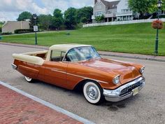 an old car is parked on the side of the road