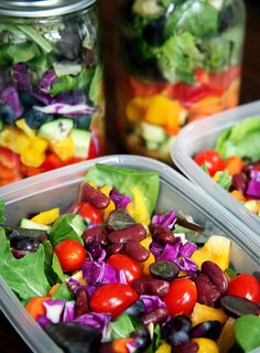 three plastic containers filled with salads on top of a table