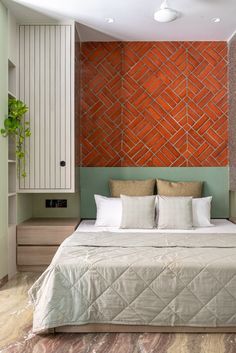 a bedroom with a large bed and orange brick wall in the corner, along with built - in shelving units