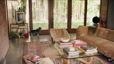 a living room filled with furniture and a glass coffee table on top of a rug