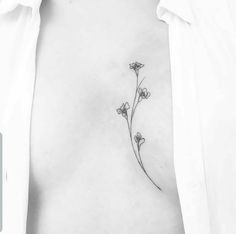 a woman's chest with three small flowers on the left side of her stomach