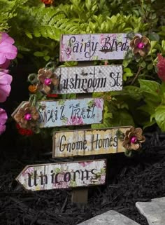 a wooden sign that has some flowers on it and other signs in the shape of arrows