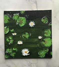 an acrylic painting of water lilies and lily pads on a green background