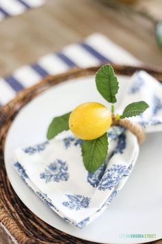 a plate with a lemon on it sitting on a place mat next to a basket