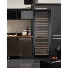 a wine cooler in the middle of a kitchen with dark cabinets and black flooring