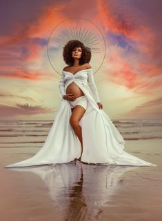 a woman in a white dress standing on the beach