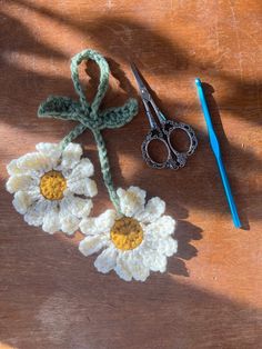 crocheted flowers and scissors on a wooden table