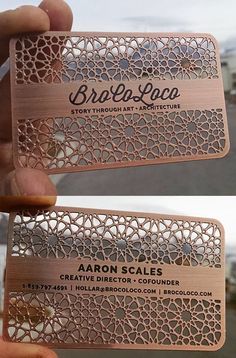 two wooden business cards with laser cut designs on the front and back, one in gold